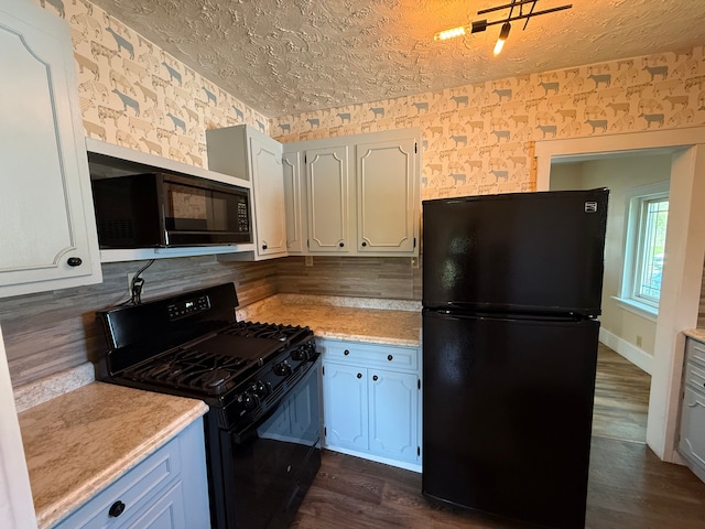 kitchen with decorative backsplash, light countertops, black appliances, wallpapered walls, and dark wood-type flooring