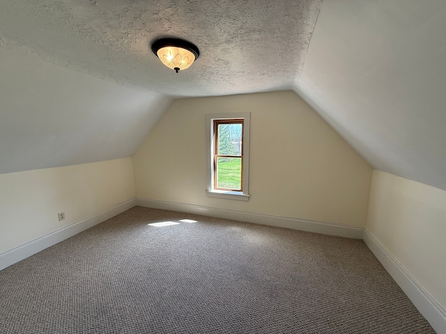 bonus room with carpet flooring, a textured ceiling, baseboards, and lofted ceiling