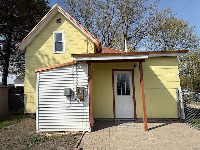 rear view of property featuring a patio area and fence