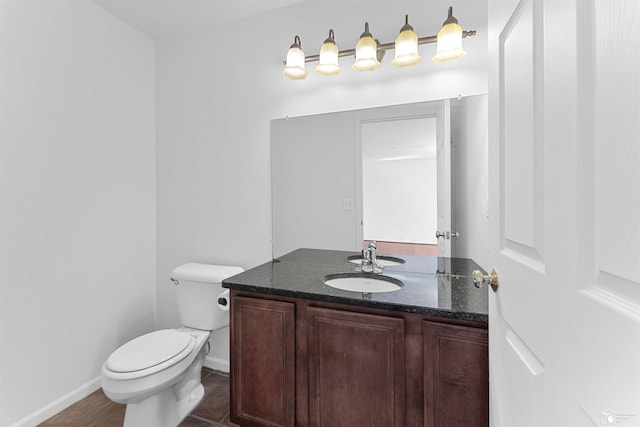 bathroom featuring vanity, baseboards, and toilet