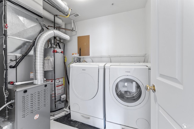 laundry room featuring laundry area, independent washer and dryer, visible vents, water heater, and heating unit