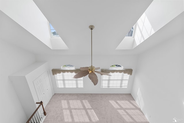details with a skylight, ceiling fan, and carpet flooring