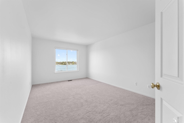 carpeted empty room featuring baseboards