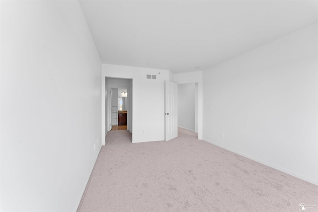 unfurnished bedroom with visible vents, baseboards, and light colored carpet