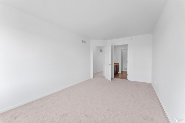 unfurnished bedroom featuring light colored carpet, baseboards, and visible vents