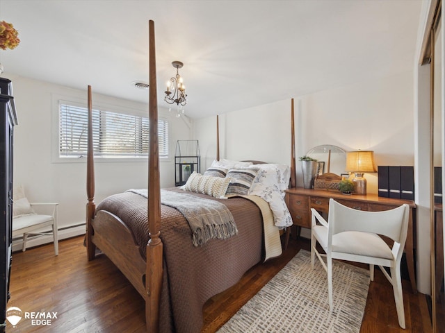 bedroom with an inviting chandelier, wood finished floors, and a baseboard radiator