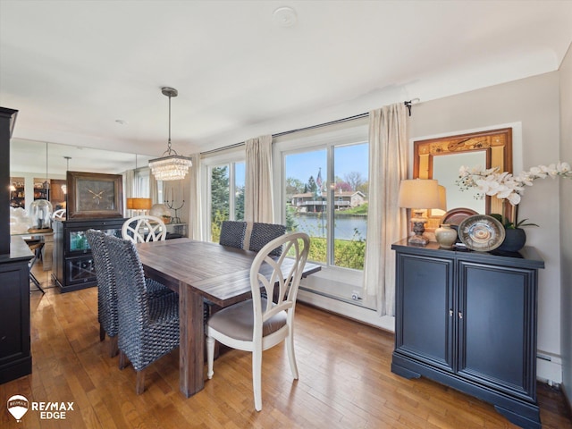 dining room featuring a chandelier, baseboard heating, and hardwood / wood-style floors