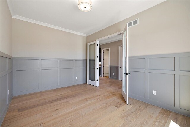 692 Westlake Ave, Oxford, MI 48371 - spare room featuring crown molding, visible vents, light wood finished floors, and a decorative wall