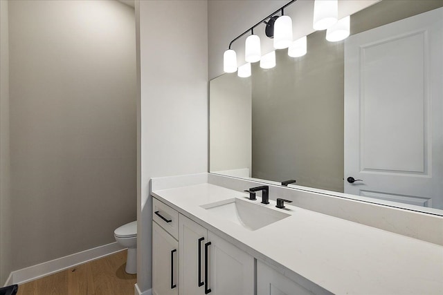 692 Westlake Ave, Oxford, MI 48371 - bathroom featuring baseboards, vanity, toilet, and wood finished floors