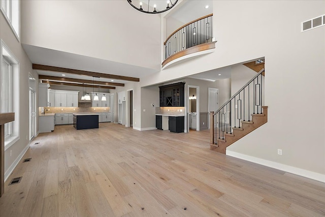 692 Westlake Ave, Oxford, MI 48371 - unfurnished living room with a high ceiling, visible vents, and light wood-style flooring