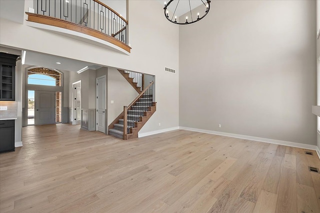 692 Westlake Ave, Oxford, MI 48371 - foyer with a chandelier, light wood-style flooring, a towering ceiling, visible vents, and stairway