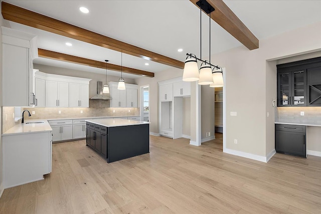 692 Westlake Ave, Oxford, MI 48371 - kitchen with wall chimney range hood, backsplash, a center island, a sink, and baseboards