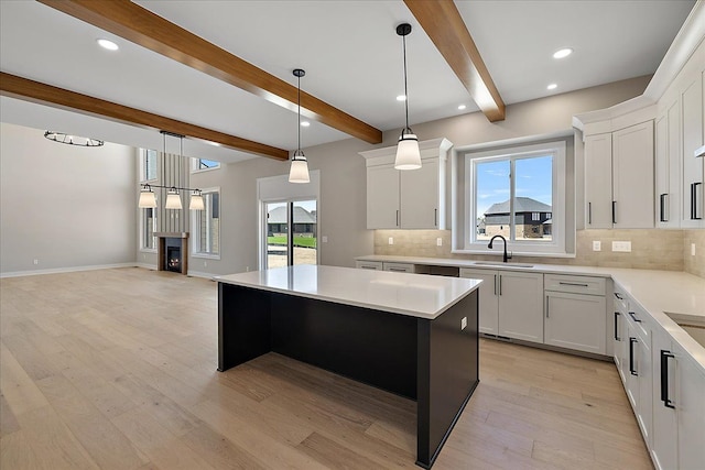692 Westlake Ave, Oxford, MI 48371 - kitchen featuring a sink, a kitchen island, beamed ceiling, and backsplash
