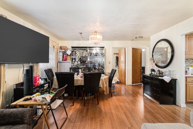 dining space with a chandelier and light wood-style flooring