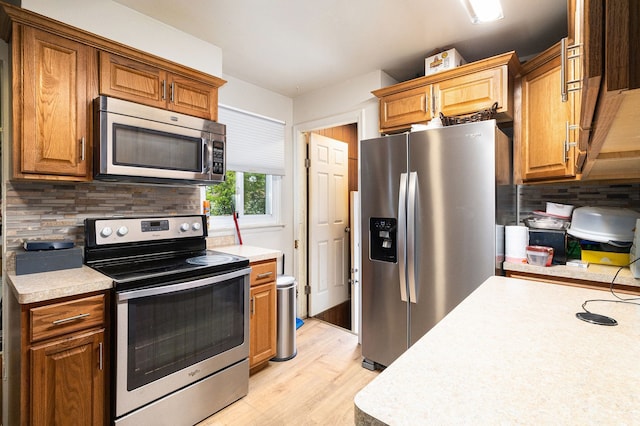 kitchen featuring stainless steel appliances, light countertops, and decorative backsplash