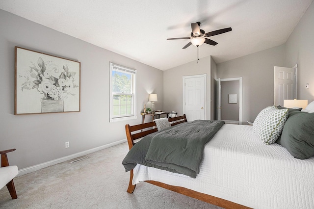 bedroom featuring a ceiling fan, visible vents, vaulted ceiling, baseboards, and carpet