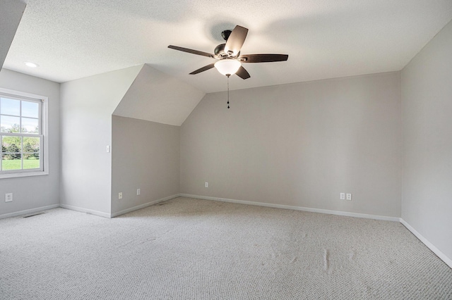 bonus room featuring ceiling fan, light carpet, a textured ceiling, baseboards, and visible vents
