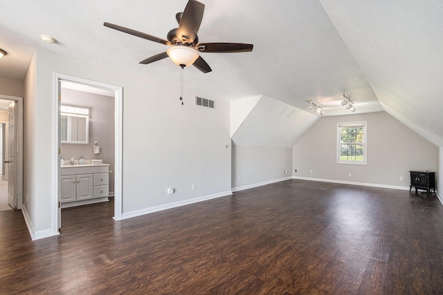 additional living space with baseboards, a ceiling fan, dark wood finished floors, and visible vents