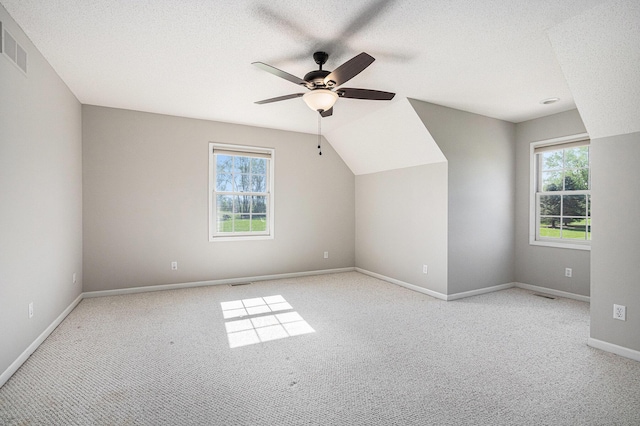 bonus room featuring carpet floors, ceiling fan, baseboards, and a wealth of natural light