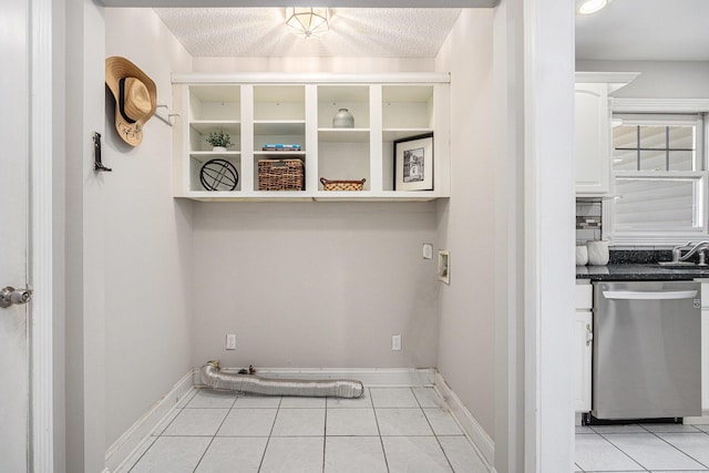washroom with light tile patterned flooring, laundry area, a sink, and hookup for a washing machine