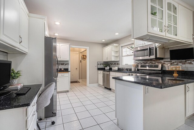 kitchen with white cabinets, backsplash, stainless steel appliances, and a peninsula