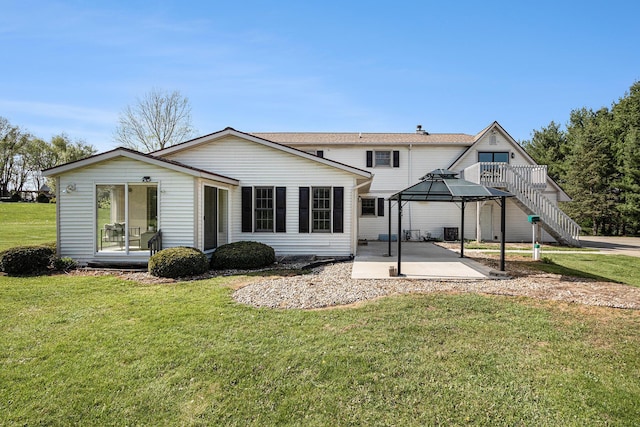 back of property featuring a lawn, a patio, and a gazebo