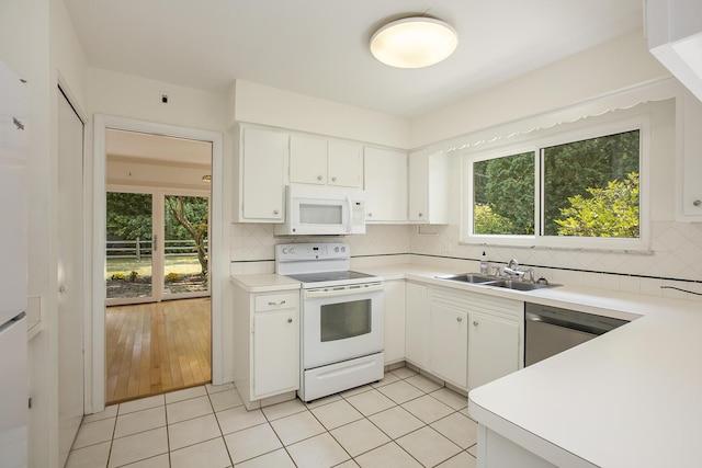 kitchen featuring white appliances, white cabinets, decorative backsplash, and a sink