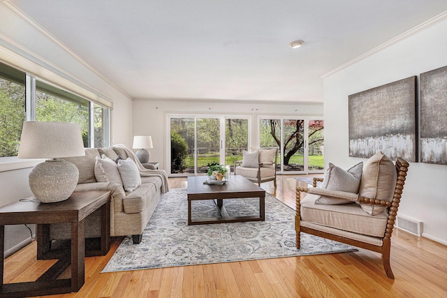 living room featuring crown molding, hardwood / wood-style flooring, and visible vents