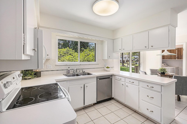 kitchen featuring decorative backsplash, light countertops, a sink, a peninsula, and white appliances