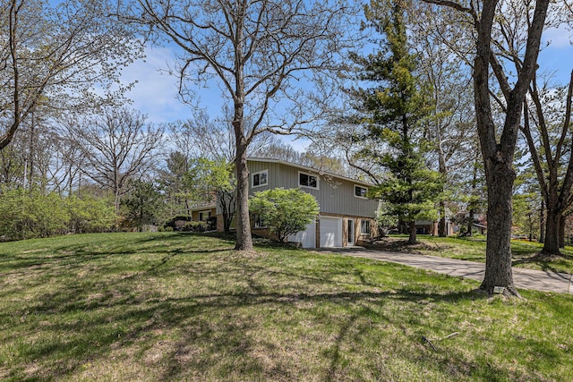 view of yard featuring a garage and driveway