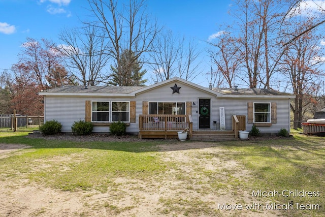 ranch-style house with fence, a wooden deck, and a front yard