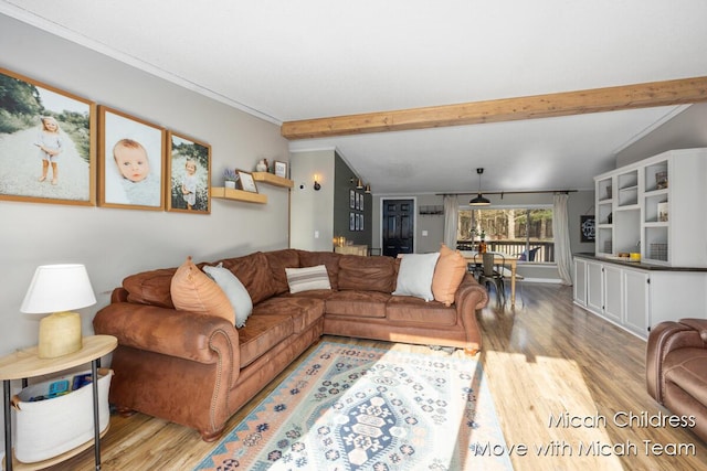 living area featuring lofted ceiling with beams and light wood-type flooring