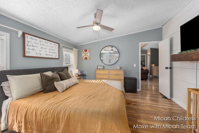 bedroom with a textured ceiling, ceiling fan, ornamental molding, and wood finished floors