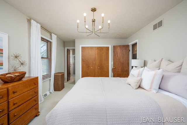 bedroom with a notable chandelier, light colored carpet, and visible vents