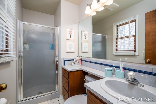bathroom featuring a stall shower, toilet, visible vents, and vanity