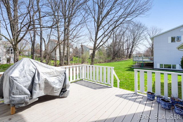 wooden terrace featuring a lawn