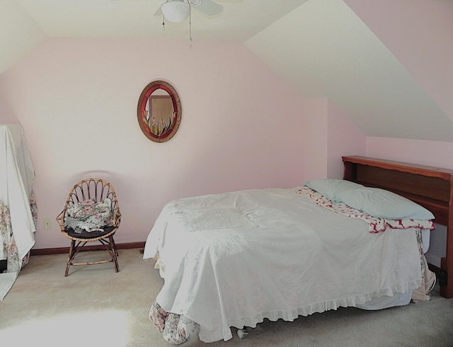 bedroom with a ceiling fan, vaulted ceiling, and carpet flooring