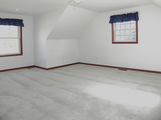 additional living space featuring visible vents, baseboards, lofted ceiling, and carpet