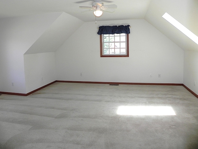 additional living space with ceiling fan, visible vents, carpet floors, baseboards, and vaulted ceiling