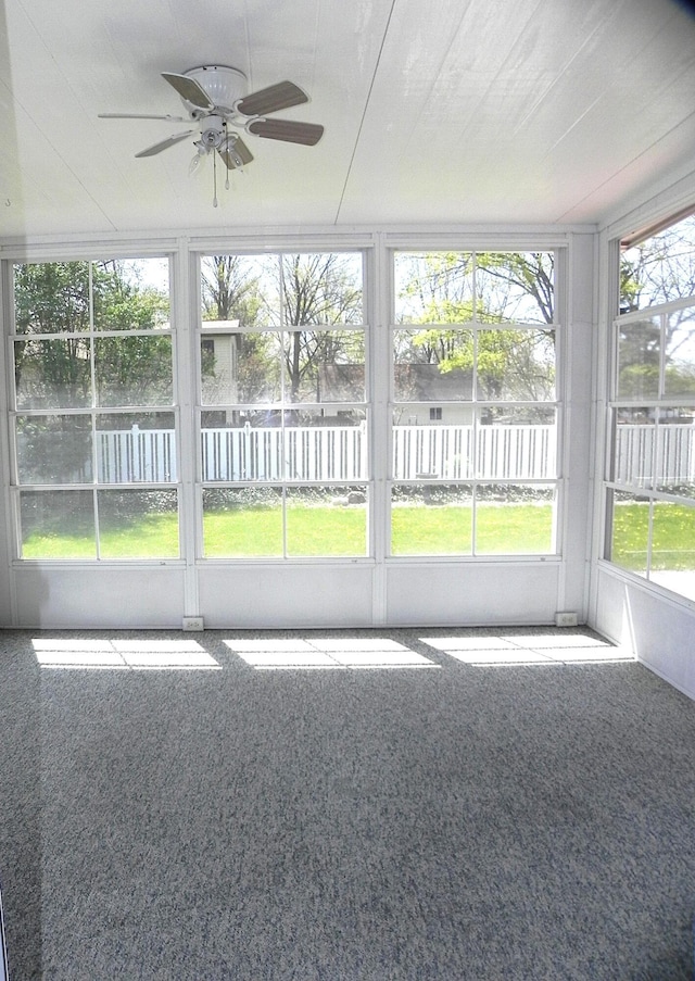 unfurnished sunroom with a ceiling fan