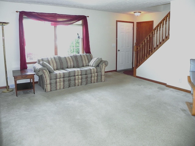carpeted living room featuring baseboards and stairway