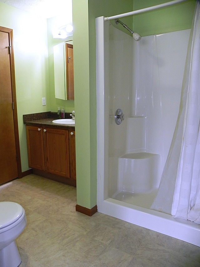 bathroom with vanity, baseboards, curtained shower, and toilet