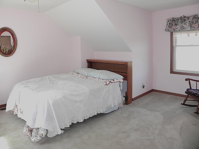 bedroom with baseboards, carpet flooring, and lofted ceiling