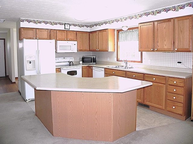 kitchen featuring a kitchen island, white appliances, light countertops, brown cabinets, and a sink