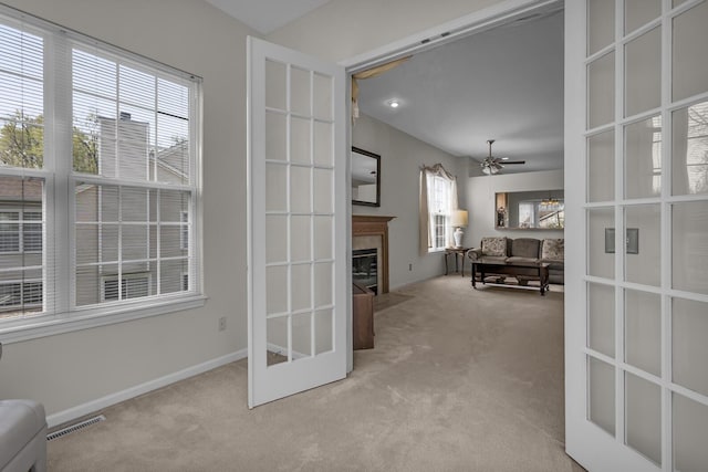 living room with visible vents, a fireplace, ceiling fan, french doors, and carpet
