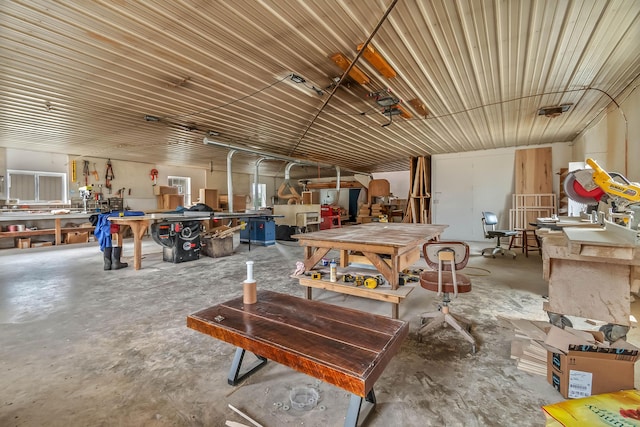 miscellaneous room featuring unfinished concrete floors, a workshop area, and a garage