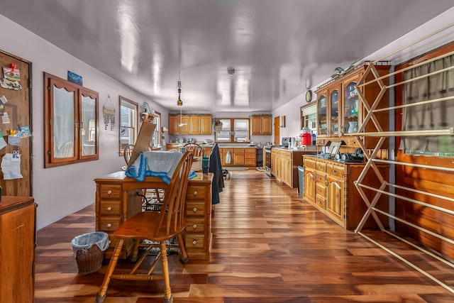 kitchen featuring glass insert cabinets, stainless steel range, brown cabinetry, and dark wood finished floors
