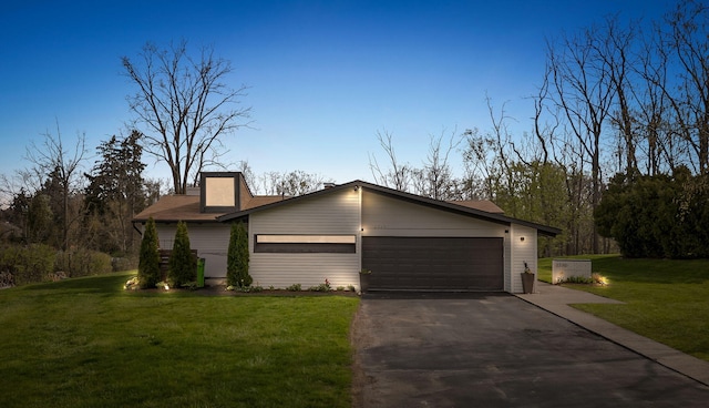 view of front facade featuring driveway, a front yard, and a garage