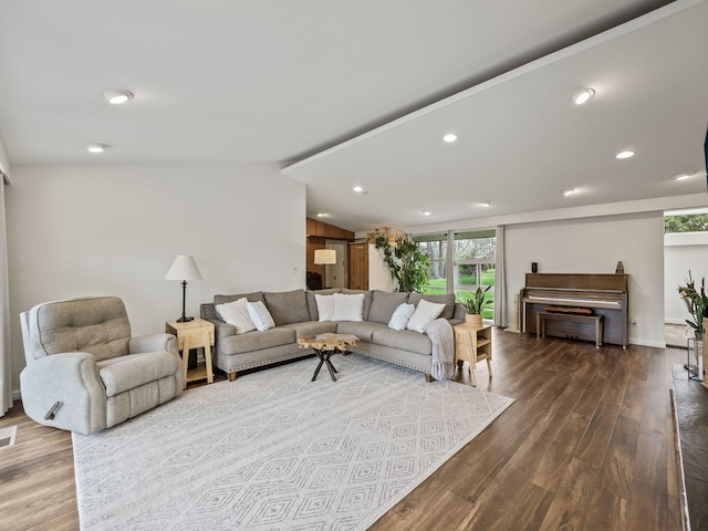 living room featuring recessed lighting, vaulted ceiling, dark wood-style flooring, and visible vents