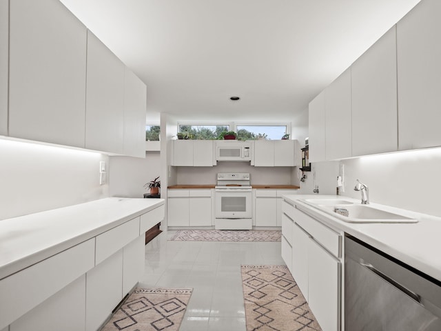 kitchen featuring a sink, white cabinets, white appliances, and light countertops